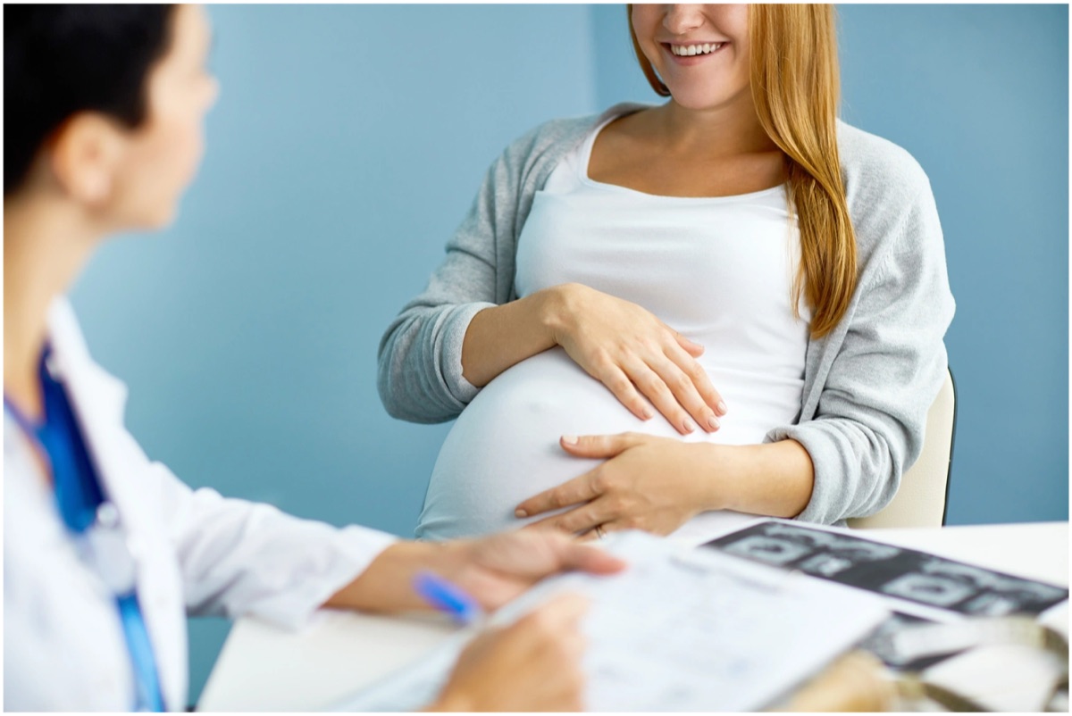 A clinician talking with a pregnant patient at a prenatal visit.